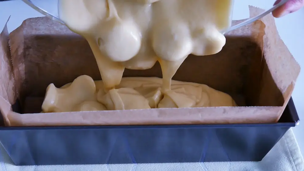 Pouring dough into the loaf pan for making banana yogurt cake