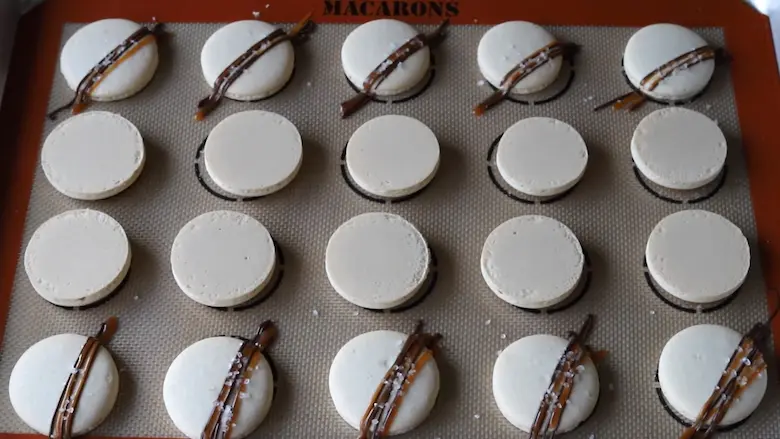 topping Salted Caramel Macarons with caramel