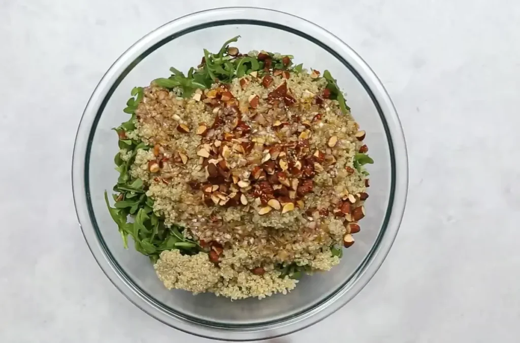 Mixing Quinoa Arugula Salad with Lemon Vinaigrette
