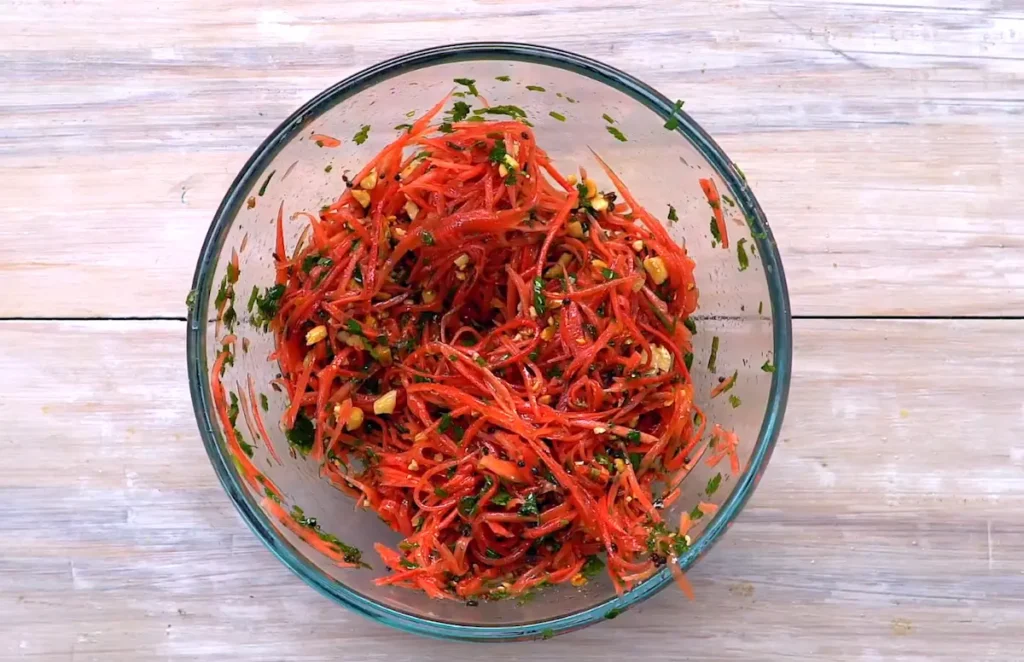 Mixing veggies and dressing in Bombay Carrot Salad